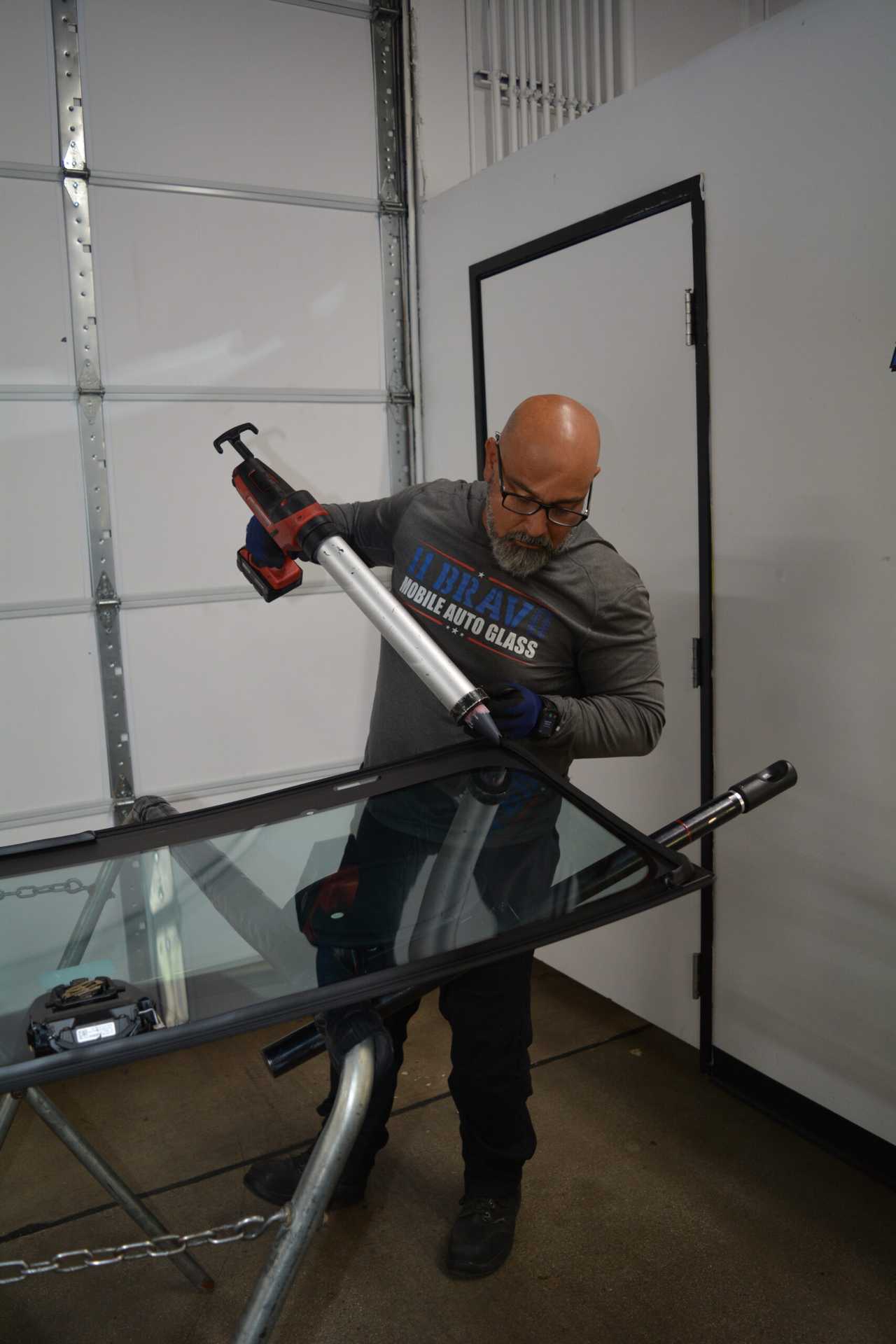 Auto glass technician applying sealant to the windshield frame in Surprise, AZ