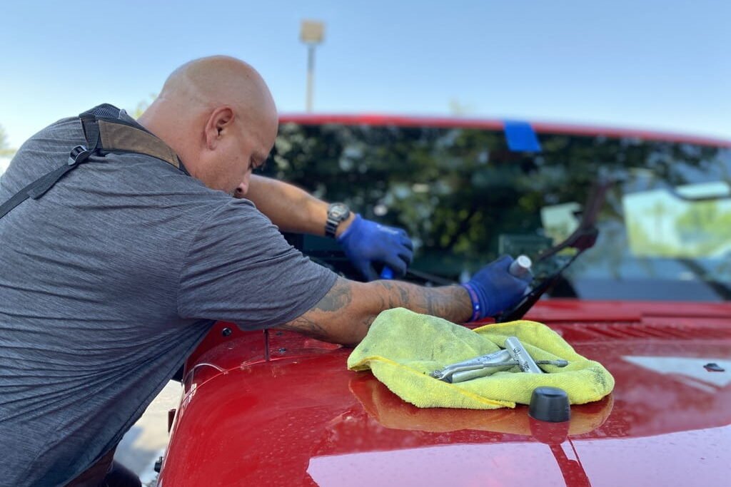 Auto glass technician installing windshield on truck outdoors in Surprise, AZ