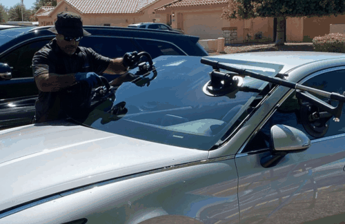 Auto glass technician using suction tools to position the windshield on a car in Surprise, AZ